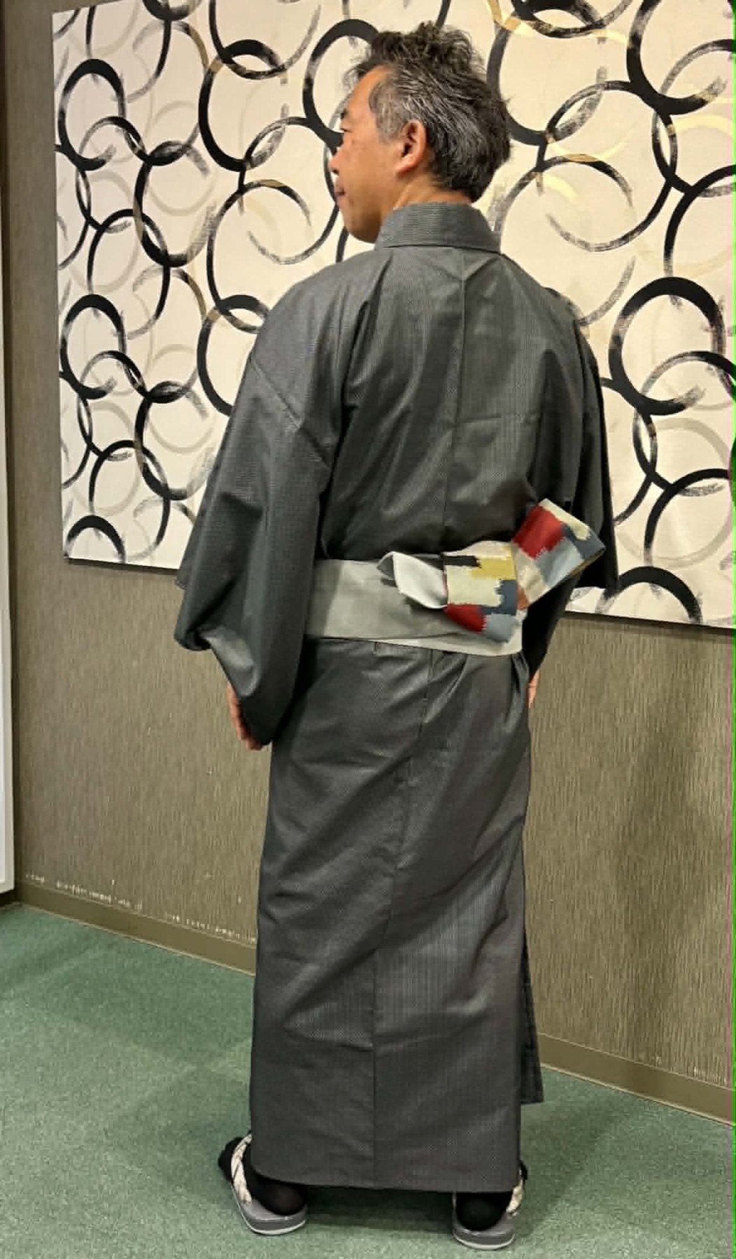 着物を着た写真家の林仁さんの後ろ姿と帯